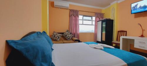 a bedroom with a bed and a couch at Hotel Platinum Class in Nueva Loja