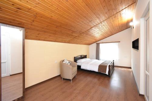 a bedroom with a bed and a wooden ceiling at Forest Hills in Yerevan
