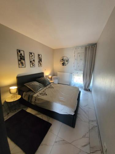 une chambre avec un lit et deux tables et une fenêtre dans l'établissement Jolie t4 a l'esplanade lez wifi, à Montpellier