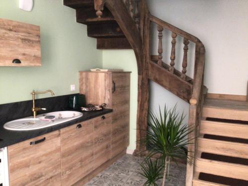 La salle de bains est pourvue d'un lavabo et d'un escalier en bois. dans l'établissement Le Doux Nid La Romantique, à Saint-Aulaye