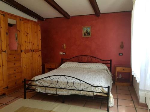 sypialnia z łóżkiem w czerwonej ścianie w obiekcie Chalet di montagna w mieście Trasacco