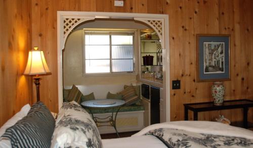 a room with a bed and a window and a table at Carmel Garden Inn in Carmel