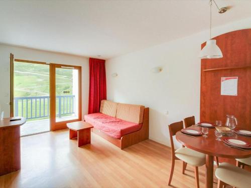 a living room with a red couch and a table at Appartement T2 4 personnes, pied des pistes, parking privé, piscine in La Mongie