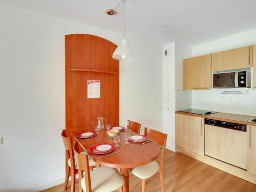 une cuisine avec une table en bois et des chaises ainsi qu'une salle à manger dans l'établissement Appartement T2 4 personnes, pied des pistes, parking privé, piscine, à La Mongie