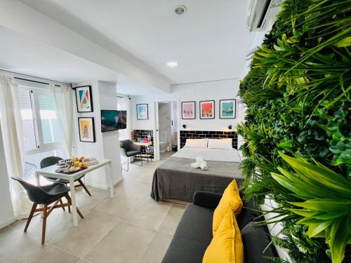 COOL LOFTS ALAMEDA VALENCIA في فالنسيا: غرفة نوم مع سرير وغرفة معيشة