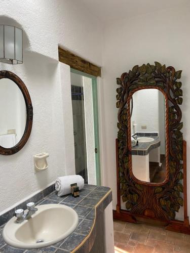 y baño con lavabo y espejo. en Casa Árbol Hotel en San Miguel de Allende