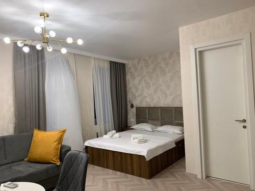 Habitación de hotel con cama y sofá en Home Plus Apartments en Tiflis