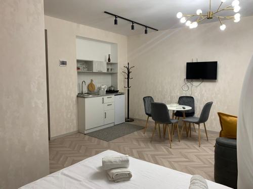 cocina y comedor con mesa y sillas en Home Plus Apartments en Tiflis