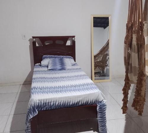 a bed sitting in a room with a mirror at Casa inteira frente p rio in Luis Correia