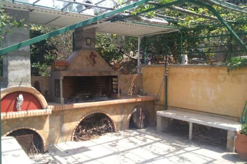 an outdoor kitchen with an outdoor oven in a patio at Trizinia view balcony in Galatas