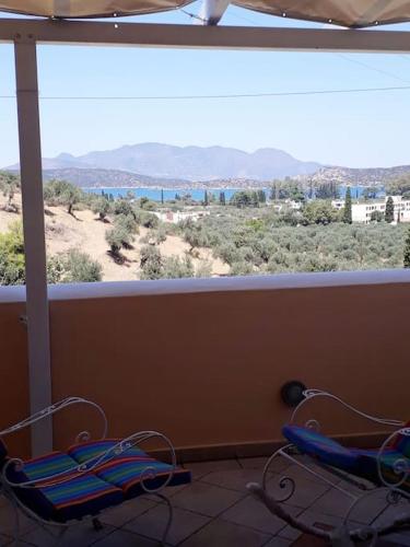 two chairs in a balcony with a view of the desert at Trizinia view balcony in Galatas