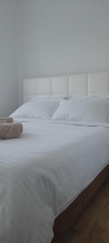 a white bed with white sheets and pillows on it at Apartmani Sunlight in Vrnjačka Banja