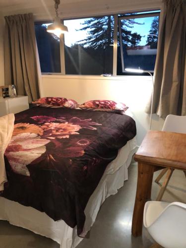 una camera da letto con un letto, un tavolo e una finestra di Almost Heaven BNB a New Plymouth