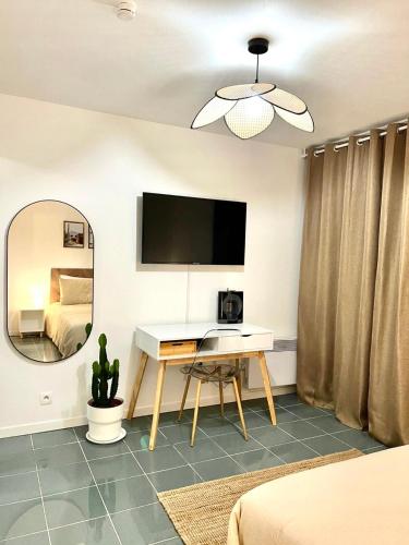 - une chambre avec un bureau et un miroir dans l'établissement Studio Compans central avec balcon - métro & Université Capitole à pied - checkIn autonome, à Toulouse