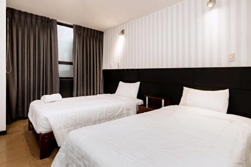 A bed or beds in a room at Miraflores Suites Centro