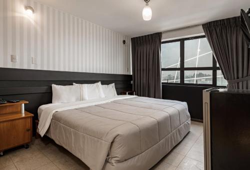 Habitación de hotel con cama grande y TV en Miraflores Suites Centro, en Lima