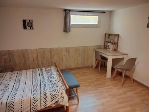 een slaapkamer met een bed, een bureau en een tafel bij chez Angélique in Marcorignan