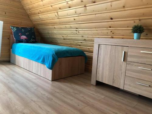 1 dormitorio con 1 cama y pared de madera en OSTOJA SŁAWIANOWO nad jeziorem, en Sławianowo