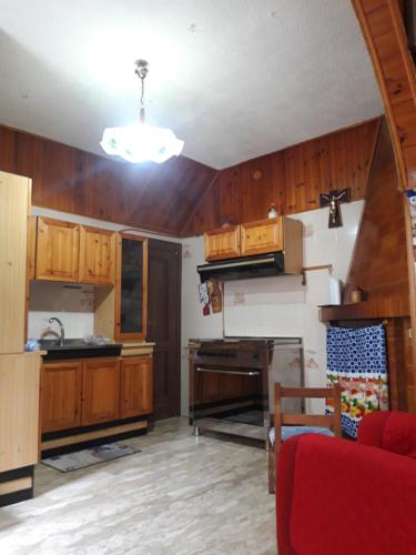 una cucina con armadi in legno e un divano rosso di casa vacanze zia Lina 