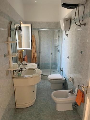 桑蒂西多羅的住宿－Villa Grandioso，浴室配有2个盥洗盆、卫生间和淋浴。