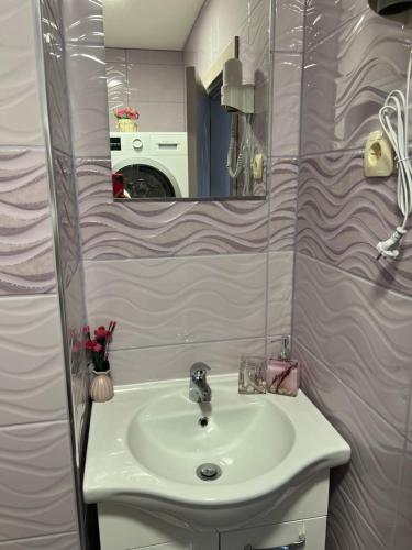 uma casa de banho com um lavatório e um espelho em Къща за гости ТАТЯНА / GUEST HOUSE TATIANA em Petrich