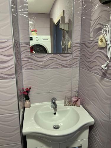 a bathroom with a sink and a mirror at Къща за гости ТАТЯНА / GUEST HOUSE TATIANA in Petrich