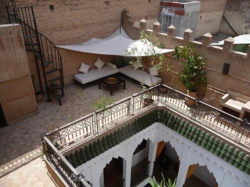 uma vista superior de uma varanda com um sofá e uma mesa em Riad Dialna em Marraquexe