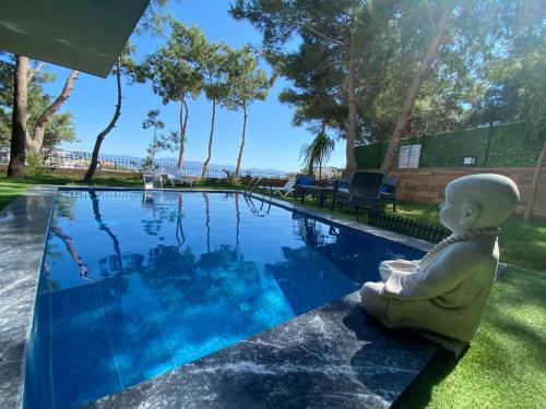 a statue sitting next to a swimming pool at Özel havuz ve deniz manzaralı yeni villa in Kusadası