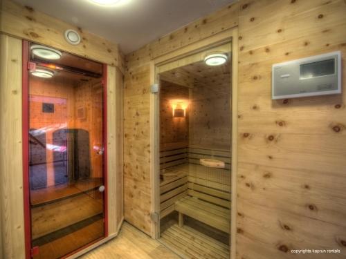 Una ducha a ras de suelo en una habitación con paredes de madera. en Residence Alpin Kaprun by Kaprun Rentals, en Kaprun