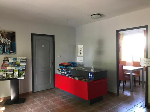a waiting room with a red counter and a table at French country home III in Les Forges