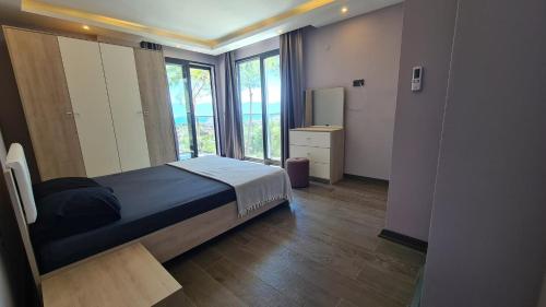 a bedroom with a bed and a large window at Özel havuz ve deniz manzaralı yeni villa in Kusadası