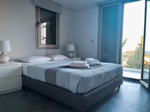 波多河麗的住宿－Porto-Cheli Sunset View House，一间卧室配有一张大床和毛巾