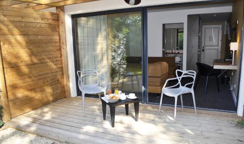 a patio with chairs and a table on a deck at Loire & Sens in Juigné-sur-Loire