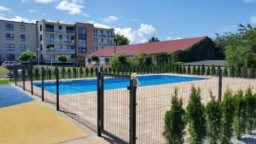 a fence in front of a swimming pool at Apartamenty Perłowa Przystań by Renters in Kołobrzeg
