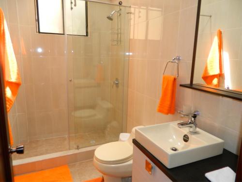y baño con ducha, aseo y lavamanos. en ItsaHome Apartments - Torre Santos, en Quito