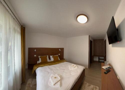 a bedroom with a bed with two towels on it at Casa Luca in Ceahlău