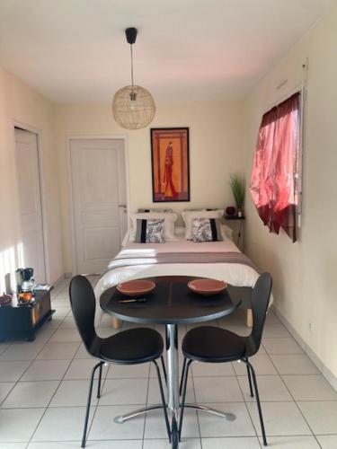 1 dormitorio con 1 cama, mesa y sillas en Chambre Is, en Is-sur-Tille