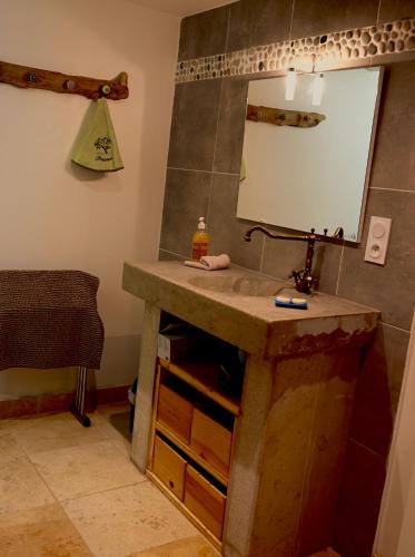 une salle de bain avec un lavabo et un miroir dans l'établissement LACOSTE, à Sainte-Colombe-en-Bruilhois