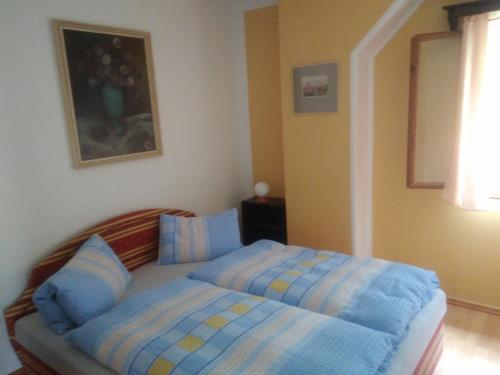 a bedroom with a bed with blue and yellow sheets at Ubytování U Sviráků in Srbská Kamenice