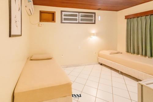 a room with two beds and a window at VOA Samuka Hotel in Florianópolis