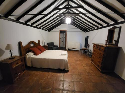a bedroom with a bed and a dresser in a room at Casa Rural Casa del Tigre in Gaucín