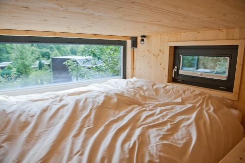 Cama en habitación con ventana en Tiny House Nature 11 - Green Tiny Village Harz, en Osterode