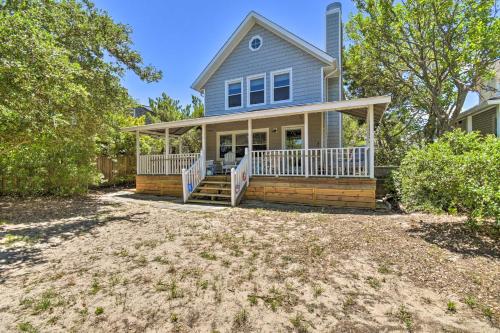 a blue house with a porch and a yard at Classic Chesapeake Beachside Cottage with Porch! in Norfolk