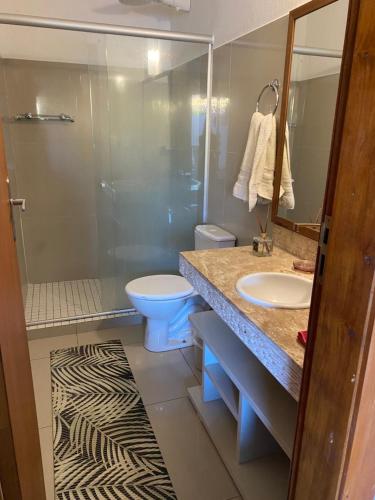 a bathroom with a shower and a sink and a toilet at Flores do Mar in Arraial d'Ajuda