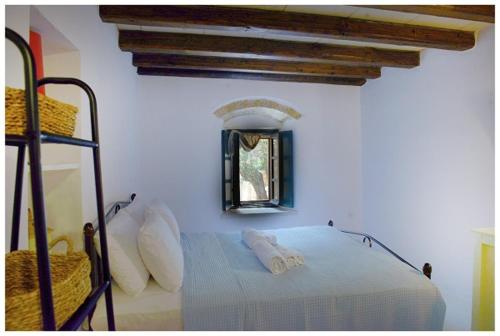 a bedroom with a bed in a room with a window at NEFELI castle stone house inside the fortress in Monemvasia