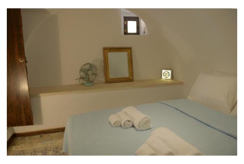 a bedroom with a bed with two towels on it at NEFELI castle stone house inside the fortress in Monemvasia