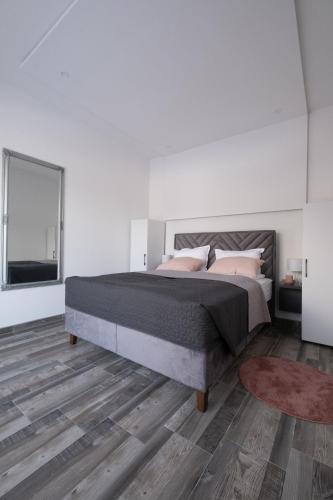 a bedroom with a large bed and a large window at Villa Kula in Bihać