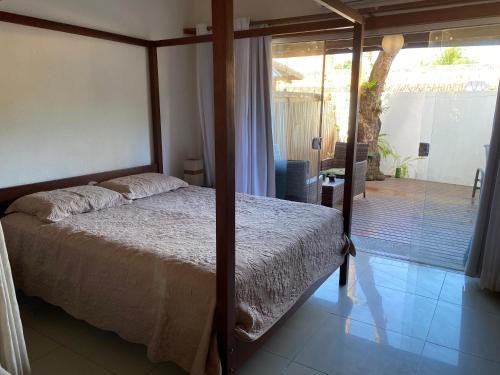 a bedroom with a bed and a sliding glass door at Flores do Mar in Arraial d'Ajuda