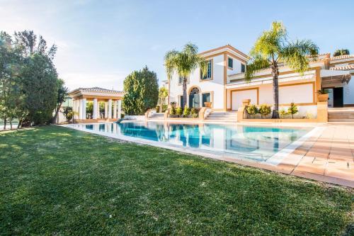 a house with a swimming pool and a yard at Cypress Villa in Albufeira