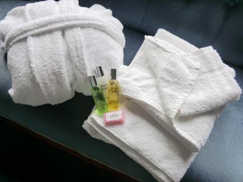 a pair of towels and a bottle of mouthwash and tooth brushes at Camfield House in Thurso